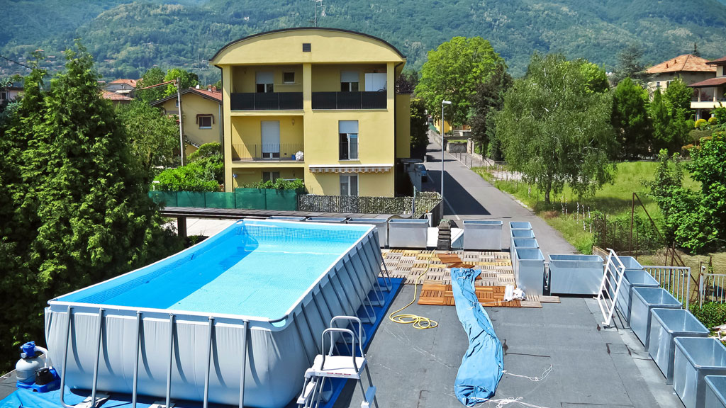 Coque polyester bleue descendue par grue dans excavation jardin résidentiel
